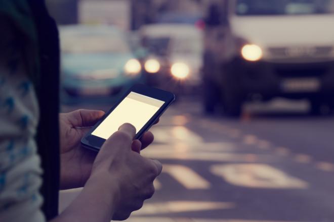 man-using-cellphone-outdoors-traffic-background