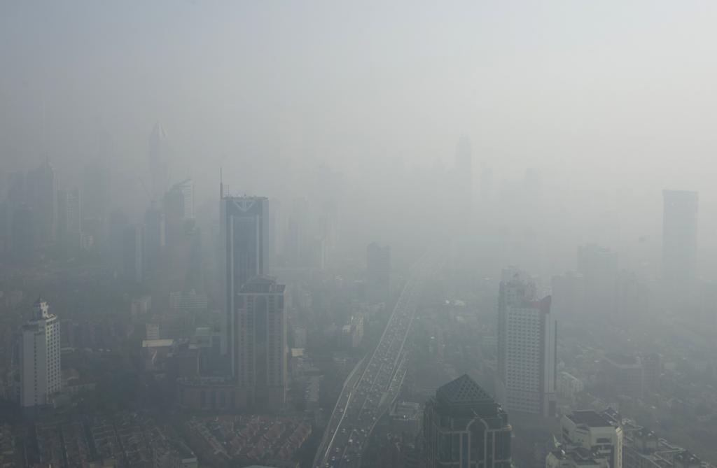 Buildings are seen through thick haze in downtown Shanghai November 7, 2013. Chinese cities should close schools, cut working hours and stop outdoor activities during the most severe spells of air pollution, the Ministry of Environmental Protection said on Wednesday. "Every possible compulsory measure" must be taken to cut emissions during the heaviest smog, which has a serious impact on health, the ministry said, including suspending factory production and imposing traffic restrictions.  REUTERS/Aly Song  (CHINA - Tags: ENVIRONMENT SOCIETY CITYSCAPE)