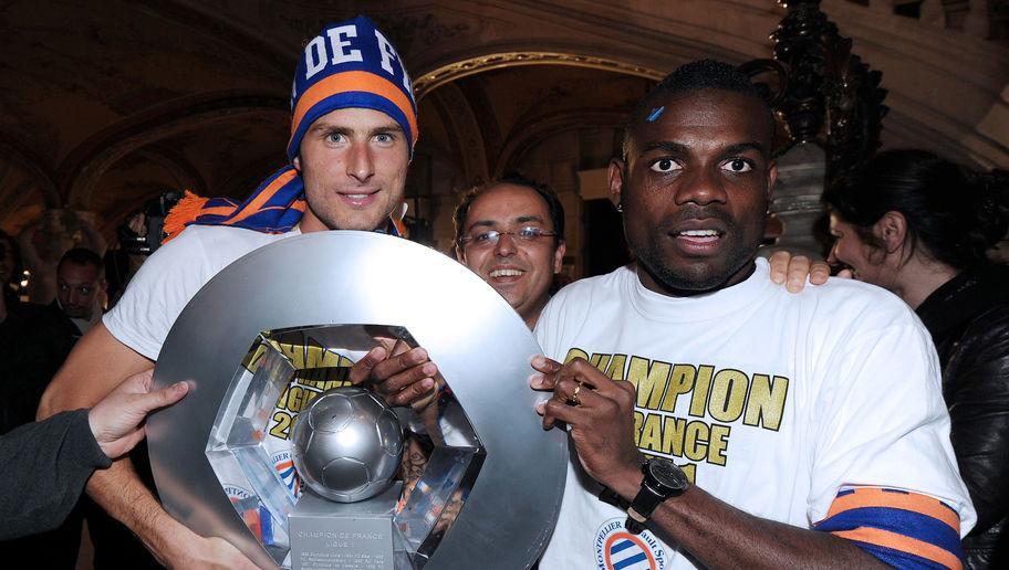 Montpellier's football club defender Henri Bedimo (R) and striker Olivier Giroud (L) hold the trophy as they celebrate with supporters, at the place de la Comedie on May 21, 2012 in Montpellier, southern France, after the club won on the eve the French L1 football championship. Montpellier finished the season three points clear of PSG in the final standings, which gave the southern club - 14th in Ligue 1 last season - their first major honour since the 1990 French Cup. AFP PHOTO / PASCAL GUYOT (Photo credit should read PASCAL GUYOT/AFP/GettyImages)