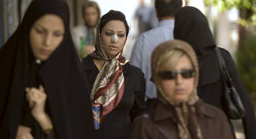 Arezoo Abassi (C) walks along a street in Tehran June 24, 2007, three weeks after undergoing nose surgery. REUTERS/Caren Firouz (IRAN) - RTR1R44J